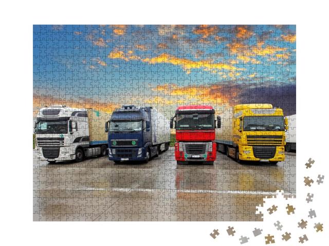 Puzzle 1000 Teile „Mehrere LKWs in verschiedenen Farben auf einem Parkplatz am Abend“