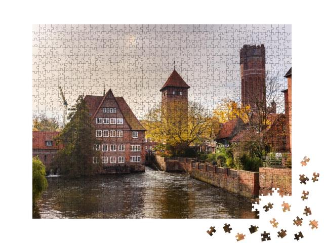Puzzle 1000 Teile „Ratsmühle oder alte Wassermühle und Wasserturm an der Ilmenau, Lüneburg“