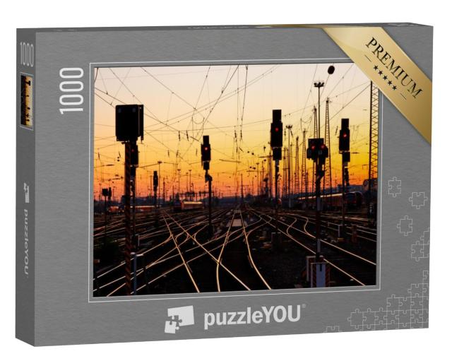 Puzzel 1000 stukjes „Spoorrails in een groot treinstation bij zonsondergang“