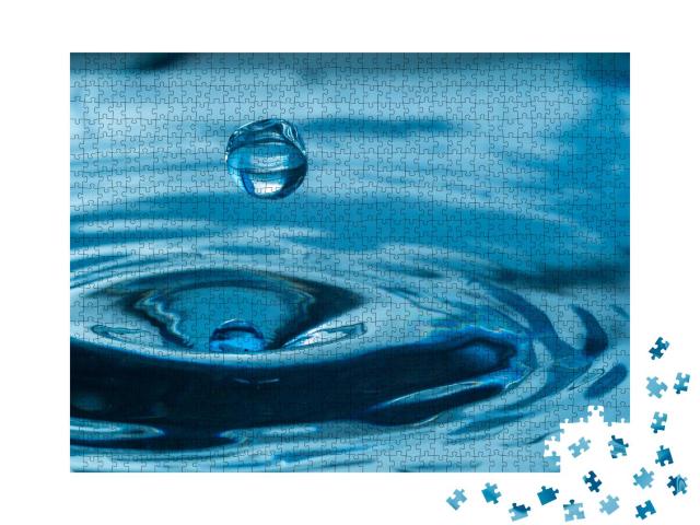 Puzzle 1000 Teile „Wassertropfen spritzen in ein Glas, blau gefärbt“
